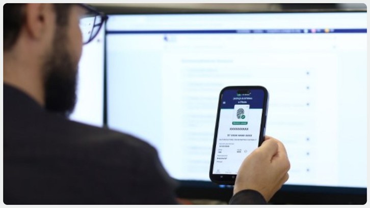 Cancelamento de títulos: eleitores já podem requerer regularização Um homem de barba, visto parcialmente de costas, segura um celular com a tela voltada para ele. ...