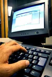 Computador Usuário usando software e digitando com munitor a frente.