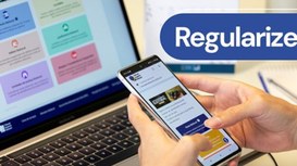 Pessoa acessando o site da Justiça Eleitoral pelo celular e computador, com destaque para a pala...