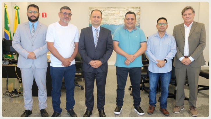 Presidente do TRE-AC recebe visita institucional do Deputado Gilberto Lira Seis homens posam lado a lado para uma foto em uma sala de reuniões. Eles estão em pé, alinhado...