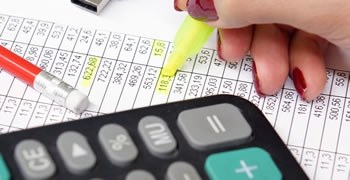 Calculadora e planilha Calculadora e planilha com números sendo destacados.