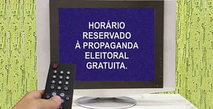 propaganda eleitoral Homem segurando controle remoto em frente a tela.